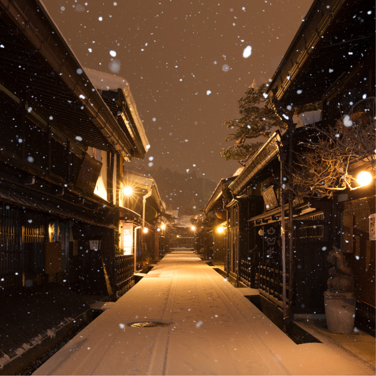 夜の雪の古い町並み